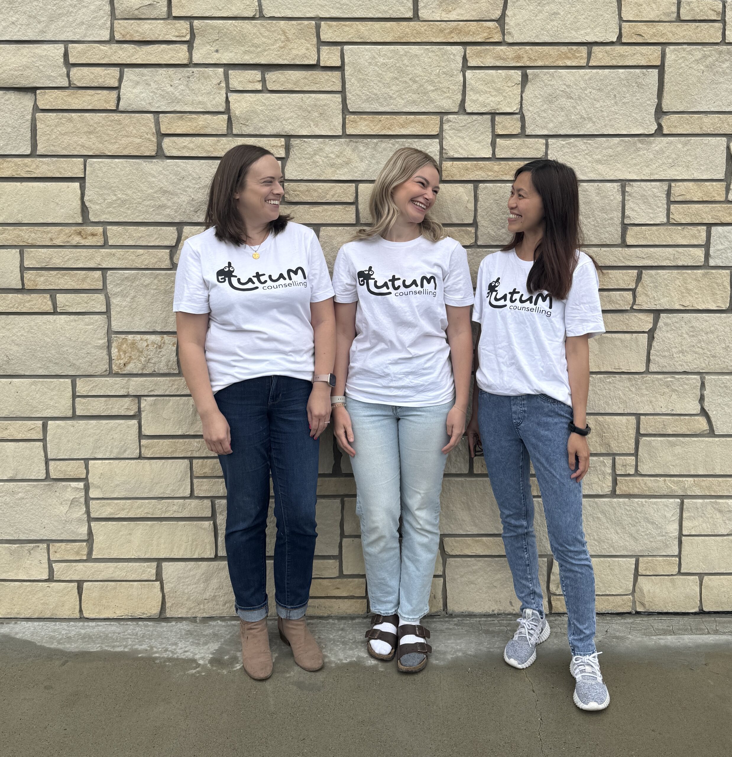 Tutum Counselling team posing in front of a brick wall